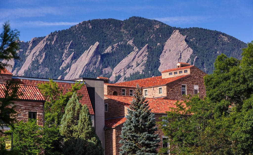 Red stone buildings and tile roofs below the Flatirons